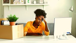 une jeune femme devant un ordinateur est inquiete car elle ne comprend pas son solde de tout compte